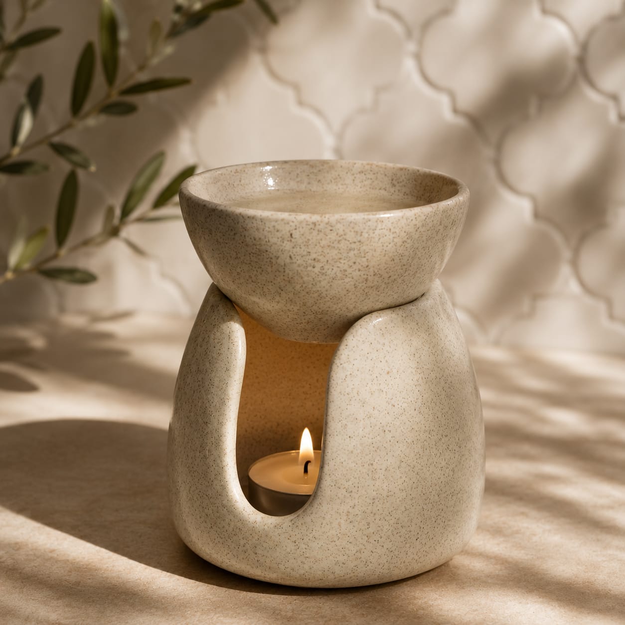 Brûle-parfum en argile blanche de Fès Terre des Huiles avec bougie chauffe-plat allumée, fond zellige blanc arabesque