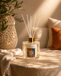 Diffuseur à roseaux Maison Terre des Huiles avec illustration riad marocain, bâtonnets blancs et bouchon doré sur fond beige